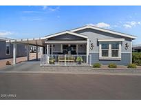 Charming single-story home featuring a covered porch, carport, and well-maintained landscaping at 2206 S Ellsworth Rd # 157B, Mesa, AZ 85209