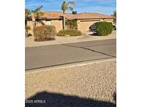 Single-story home with a two-car garage, desert landscaping and a paved street at 32071 N Chestnut Trl, San Tan Valley, AZ 85143