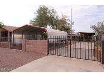 Gated home features two carports, a block wall, and mature landscaping at 502 W 11Th St, Casa Grande, AZ 85122