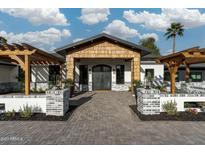 Stunning home entrance with a striking wooden gable and an inviting brick pathway to the custom double doors at 7014 E Palo Verde Ln, Paradise Valley, AZ 85253