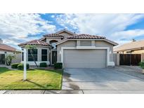 Charming single-story home with a well-maintained lawn, two-car garage, and Southwestern-style architecture at 7923 W Taro Ln, Glendale, AZ 85308