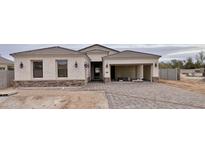 Stunning single-story home featuring a paved driveway, stone accents, and a welcoming open-concept garage at 1586 N Himosa Dr, Casa Grande, AZ 85122