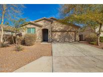 Inviting single-story home featuring a well-kept front yard, a neutral color palette, and a two-car garage at 21198 W Berkeley Rd, Buckeye, AZ 85396