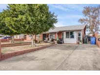 Charming single-story home with a well-kept front yard and comfortable seating on the front porch at 6418 W Thomas Rd, Phoenix, AZ 85033