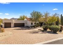 A luxurious home showcasing a paved driveway leading to a multi-car garage and meticulously landscaped front yard at 9370 E Calle De Las Brisas --, Scottsdale, AZ 85255