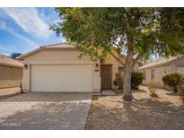Charming single-story home featuring a well-maintained front yard, desert landscaping and an attached two-car garage at 991 E Monteleone St, San Tan Valley, AZ 85140