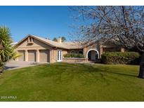 Charming single-story home featuring a well-manicured lawn, arched entry, and a three-car garage in a residential neighborhood at 15217 N 60Th St, Scottsdale, AZ 85254