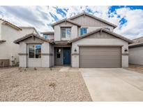 Two-story home boasts a neutral color scheme, two car garage, and desert landscaping at 18433 W Monte Lindo Ln, Surprise, AZ 85387