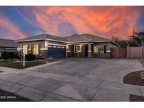 Charming home exterior featuring a wide driveway and rock accents against a vivid sunset at 3456 E Joseph Way, Gilbert, AZ 85295