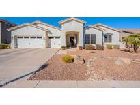 Beautiful single-story home featuring a three-car garage, landscaped yard and a charming entry gate at 3706 E Ravenswood Dr, Gilbert, AZ 85298