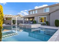 A beautiful pool with a hot tub and seating areas, with the two story home as a backdrop at 3930 E Enrose St, Mesa, AZ 85205