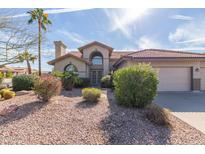 Inviting home features desert landscaping, a tile roof, and a two-car garage at 5865 E Jasmine St, Mesa, AZ 85205