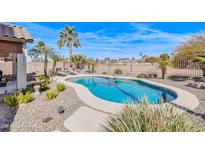 Backyard oasis with a refreshing pool, palm trees, desert landscape, and lounge chairs at 6579 S Classic Way, Gilbert, AZ 85298