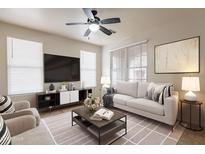 Cozy living room featuring neutral colors, a ceiling fan, comfortable seating, and modern decor at 1088 S Storment Ln, Gilbert, AZ 85296
