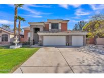 Inviting two-story home showcasing a spacious driveway, three car garage, stone accents and lush green lawn at 20709 N 59Th Dr, Glendale, AZ 85308