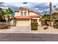 Inviting two-story home featuring a red tile roof, desert landscaping, and a spacious two car garage at 3236 E Tanglewood Dr, Phoenix, AZ 85048