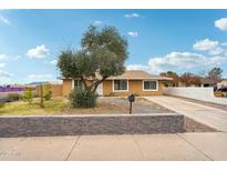 Charming single-story home featuring a well-maintained front yard and a long driveway at 3802 N 73Rd Ave, Phoenix, AZ 85033