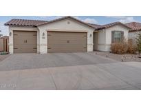 Charming home with a three-car garage, tile roof, and a paved driveway at 40520 W Haley Dr, Maricopa, AZ 85138