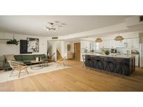 Open concept living room with a kitchen island, hardwood floors, and modern furnishings at 8740 E Mulberry St, Scottsdale, AZ 85251