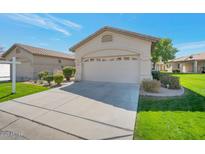 Charming home featuring a well-manicured lawn and a two-car garage with desert landscaping at 9705 E Carefree Way, Chandler, AZ 85248