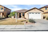 Charming single-story home with a two-car garage, desert landscaping, and a tiled roof at 18298 N Kari Ln, Maricopa, AZ 85139
