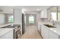 A bright kitchen with stainless steel appliances, white cabinets, and quartz countertops at 2157 N Recker Rd, Mesa, AZ 85215