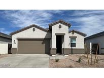 Attractive single-story home with a symmetrical facade, neutral stucco, and a well-maintained front yard at 25372 W Sunland Ave, Buckeye, AZ 85326