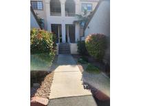 Inviting condo exterior with well maintained walkway, beautiful flowering bushes, and covered entrances at 10080 E Mountainview Lake Dr # 110, Scottsdale, AZ 85258