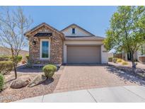 Charming single-story home featuring stone accents and a paved driveway leading to an attached two-car garage at 12035 W Roy Rogers Rd, Peoria, AZ 85383