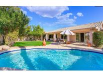 Gorgeous backyard oasis featuring a sparkling pool, lush lawn, and covered patio perfect for outdoor living at 20218 N 61St Ave, Glendale, AZ 85308