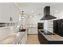 Modern kitchen featuring granite countertops, stainless steel appliances, island cooktop, and white cabinetry at 2366 E Shea Blvd, Phoenix, AZ 85028