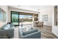 Bright living room with modern furnishings and an open view to the patio and desert landscape at 3045 W Feather Sound Dr, Anthem, AZ 85086