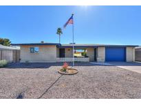 Charming single-Gathering home with desert landscaping and a blue accent garage door at 6319 E Duncan St, Mesa, AZ 85205