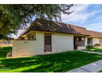 Charming one-story home featuring well-manicured lawn and inviting curb appeal on a bright, sunny day at 8161 N 107Th Ave # 104, Peoria, AZ 85345
