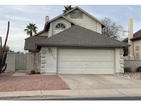 Two-story home featuring an attached two-car garage, desert landscaping, and a well-maintained exterior at 1614 E Javelina Cir, Mesa, AZ 85204