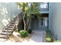 Building entrance with desert landscaping, a small tree, and stairway to the second floor at 2929 W Yorkshire Dr # 1028, Phoenix, AZ 85027