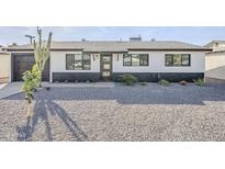 Charming home featuring a low maintenance gravel yard, black and white exterior paint, and desert landscaping at 1238 N 78Th St, Scottsdale, AZ 85257