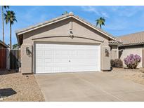 Exterior of the home showing a two-car garage and desert landscaping with palm trees at 20218 N 33Rd Pl, Phoenix, AZ 85050