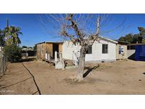 Exterior view of a single-story home with peeling white paint in disrepair and sparse landscaping at 508 S 98Th St, Mesa, AZ 85208