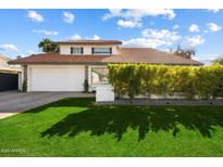 Charming two-story home featuring lush front lawn, tile roof, and a two-car garage at 8607 N Farview Dr, Scottsdale, AZ 85258