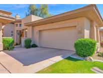 Attached two-car garage with manicured lawn and landscaping at 15240 N Clubgate Dr # 117, Scottsdale, AZ 85254