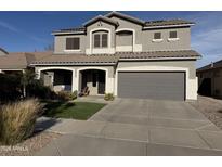 Beautiful two-story home featuring a well-manicured lawn, covered entryway, and a two-car garage at 22803 S 215 St, Queen Creek, AZ 85142