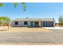 Charming single-story home with a gravel front yard, blue door, and attached garage at 28213 N Holly Rd, San Tan Valley, AZ 85143