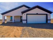 New construction home showcasing a simple landscape and a bright white facade with black trim at 37567 W Roosevelt St, Tonopah, AZ 85354