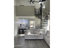 Bright living room with a spiral staircase, open kitchen, and modern furnishings at 4901 S Calle Los Cerros Dr # 206, Tempe, AZ 85282