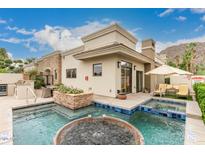 Inviting pool area featuring a spa, lounge chairs, and a built-in grill, perfect for relaxation and outdoor entertaining at 6000 E Camelback Rd # 7705, Scottsdale, AZ 85251
