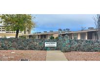 Exterior view of the Madera community entrance with stone wall and well-maintained landscaping at 10540 W Coggins Dr # 1C, Sun City, AZ 85351