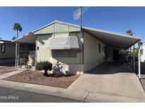 Charming single-story home featuring a covered driveway, desert landscaping, and a welcoming facade at 4065 E University Dr # 556, Mesa, AZ 85205