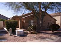 Charming single-story home with an arched entryway and desert landscaping under a mature shade tree at 455 W Gary Ave, Gilbert, AZ 85233