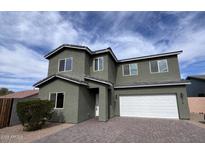 Two-story home features a finished two car garage and a brick paver driveway at 514 W Desert Ln, Phoenix, AZ 85041